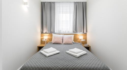 ein Schlafzimmer mit einem Bett mit zwei Kissen darauf in der Unterkunft Ariańska 6 Apartments by LET'S KRAKOW in Krakau