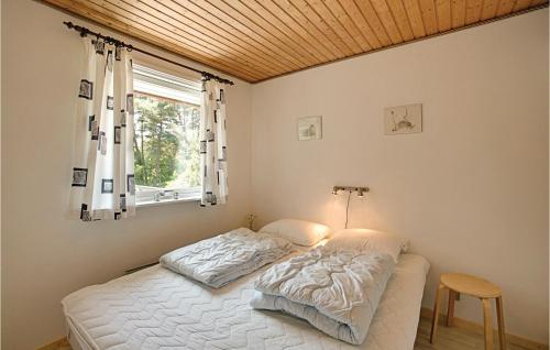 Vester SømarkenにあるAwesome Home In Aakirkeby With 3 Bedrooms And Wifiのベッドルーム1室(ベッド1台、窓、テーブル付)