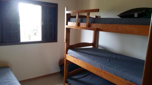 Dos literas en una habitación con ventana. en Chácara em Atibaia, en Atibaia