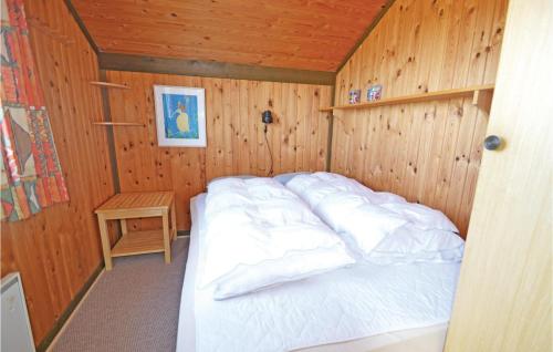 Bjerregårdにある3 Bedroom Cozy Home In Hvide Sandeの木製の部屋にベッド1台が備わるベッドルーム1室があります。