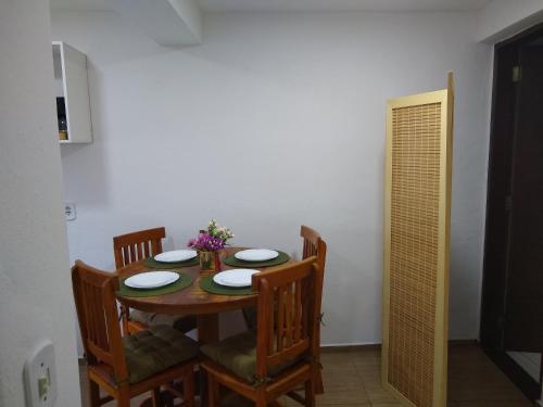 a dining room table and chairs with plates and flowers on it at Chalé Topázio in Monte Verde