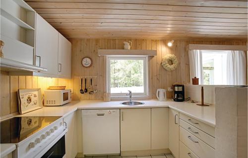 a kitchen with white cabinets and a window and a sink at Hubertus in Spidsegård