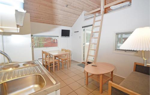 una cocina y comedor con una escalera en una casa pequeña en Juelsminde Campinghytte, en Juelsminde