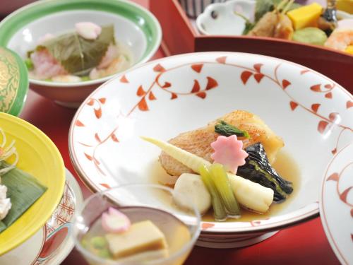 a plate of food on a table with other plates of food at Hanamomiji in Jozankei