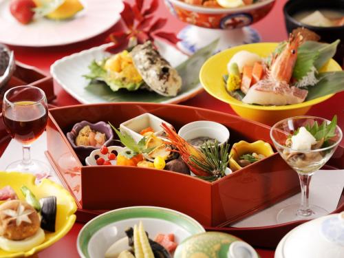 a table with plates of food and glasses of wine at Hanamomiji in Jozankei