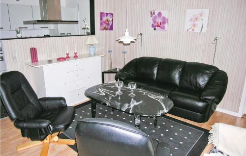 a living room with a leather couch and a table and chairs at Holiday Home Bygtoften Glesborg Vi in Glesborg