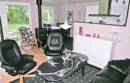 a living room with black leather chairs and a table at Holiday Home Bygtoften Glesborg Vi in Glesborg