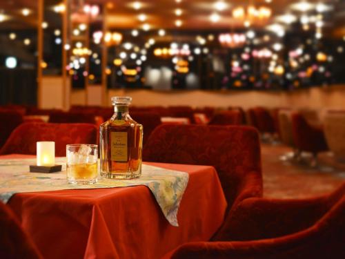 a bottle of whiskey sitting on a table with a glass at Hanamomiji in Jozankei