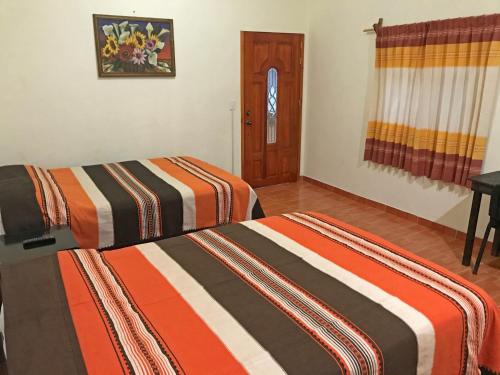 a bedroom with two beds and a door at Casa Elim-Oaxaca in Teotitlán del Valle