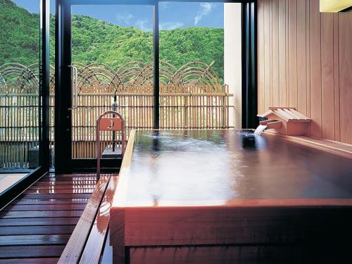 a wooden table in a room with a large window at Hanamomiji in Jozankei
