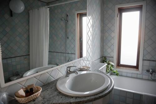 bagno con lavandino, vasca e specchio di Corte Baldi a Galatina