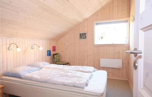 HavrvigにあるNice Home In Hvide Sande With 3 Bedrooms And Wifiの木製の壁のベッドルーム1室