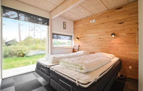 エーベルトフトにあるAmazing Home In Ebeltoft With 4 Bedrooms And Wifiの大きな窓付きの客室で、ベッド2台が備わります。