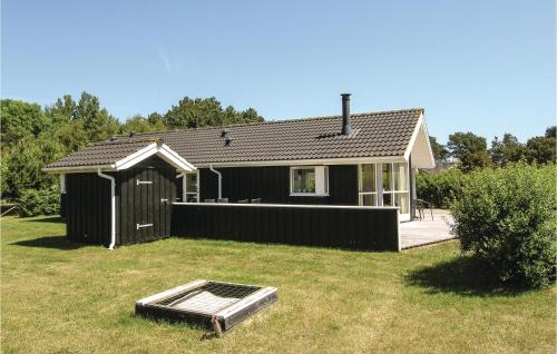 a small black house with a roof on a yard at Holiday Home Enebærvænget Humble Ii in Nyby