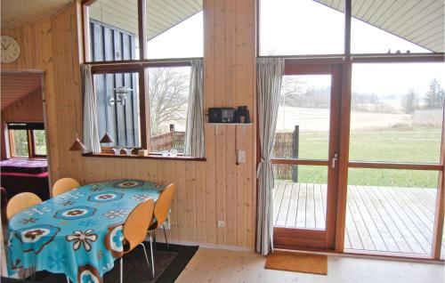 uma sala de jantar com uma mesa e algumas janelas em Nice Home In Vordingborg With 2 Bedrooms And Wifi em Næs