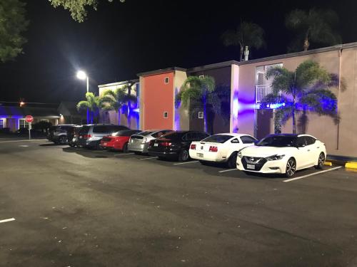 a row of cars parked in a parking lot at night at Tropical Inn & Suites, downtown clearwater in Clearwater