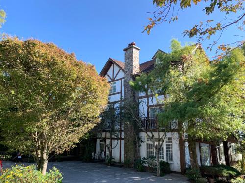 a large house with trees in front of it at The Cotswolds Villa in Renai