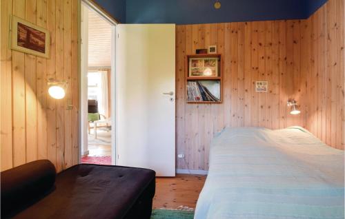 a bedroom with wooden walls and a bed in a room at Three-Bedroom Holiday Home In Humble in Humble