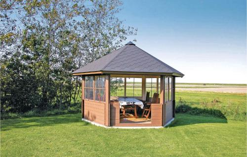 a gazebo with a table and chairs in the grass at Holiday Home Østerende in Ballum