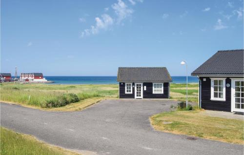 two small houses on a road next to the ocean at Holiday Home Strandgårdsvej Bagenkop Denm in Bagenkop