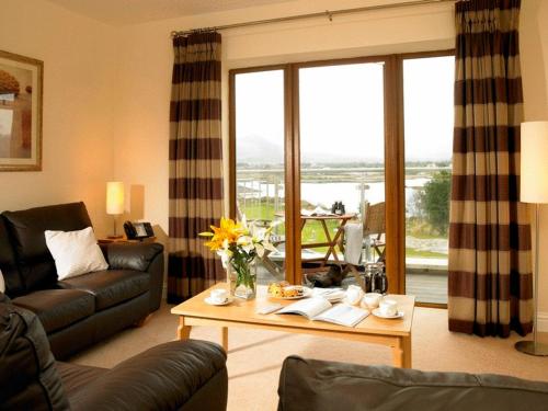 ein Wohnzimmer mit einem Sofa und einem Tisch mit Blumen in der Unterkunft Golden's Cove Apartments at Sneem Hotel in Sneem