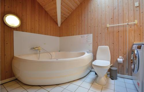 a bathroom with a tub and a toilet at Awesome Home In Ebeltoft With 4 Bedrooms, Sauna And Wifi in Ebeltoft