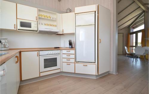 a kitchen with white cabinets and a refrigerator at Holiday Home Fanø 9 in Sønderho
