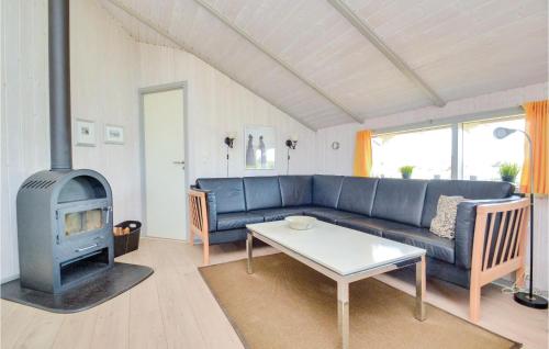 een woonkamer met een blauwe bank en een open haard bij Amazing Home In Fan With Sauna in Sønderho