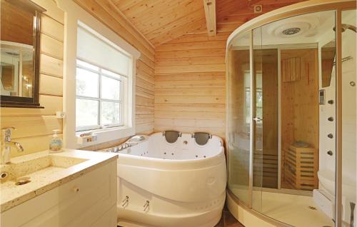 y baño grande con bañera y ducha. en 3 Bedroom Cozy Home In Aakirkeby, en Åkirkeby