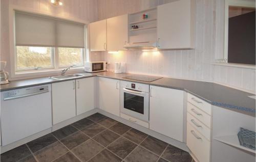 Nice Home In Hirtshals With 3 Bedrooms في هيرتسهلس: مطبخ أبيض مع دواليب بيضاء ومغسلة