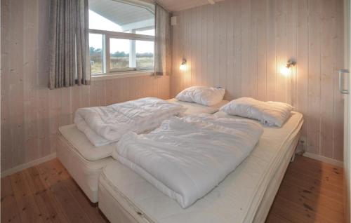 Nice Home In Hirtshals With 3 Bedrooms في هيرتسهلس: سرير أبيض كبير في غرفة مع نافذة