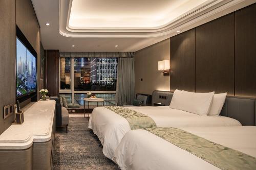 a hotel room with two beds and a television at Oriental Riverside Bund View Hotel (Shanghai International Convention Center) in Shanghai