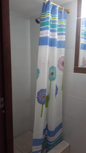 a shower curtain with blue flowers on it in a bathroom at Hostal Villa Brisa in Ballenita