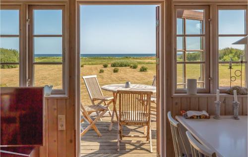 a porch with a table and a view of the ocean at Holiday Home Æblerosevej in Yderby