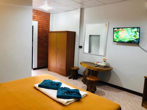 una stanza con un letto e una TV su una parete di Lovely Lanta Resort a Ko Lanta