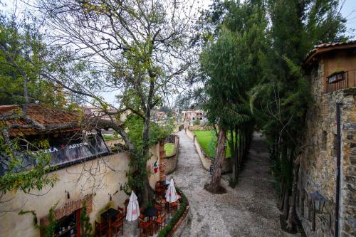 an alley with trees and umbrellas next to a building at Villa Toscana ValQuirico Lofts & Suites Hotel Boutique in Santeagueda
