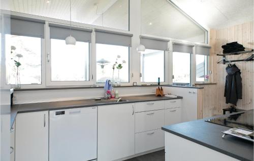 SaltumにあるBeautiful Home In Saltum With 5 Bedrooms, Wifi And Indoor Swimming Poolの白いキャビネットと窓付きの白いキッチン