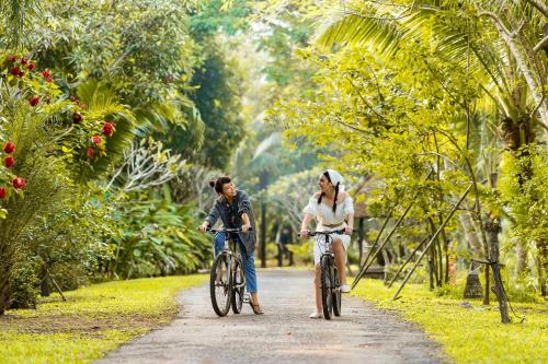 a man and a woman riding bikes down a path at River Kwai Resotel - SHA Extra Plus in Sai Yok