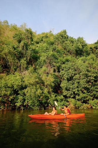 two people in a red kayak on a river at River Kwai Resotel in Sai Yok