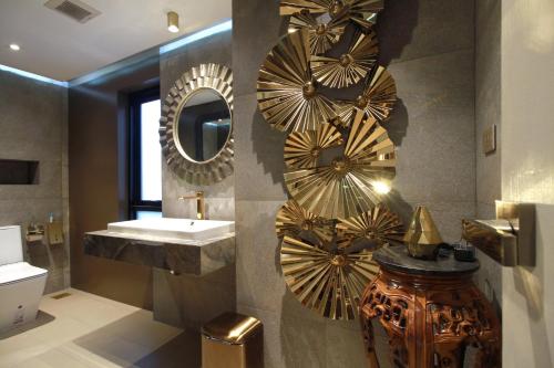 a bathroom with a sink and mirrors on the wall at Mybed Chonburi in Ban Nong Tako