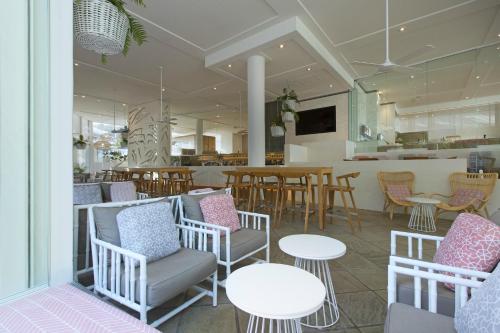 a restaurant with white tables and chairs and a counter at Sofitel Noosa Pacific Resort in Noosa Heads