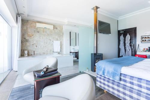 a bedroom with a bed and a bathroom with a tub at Head over Hills in Knysna