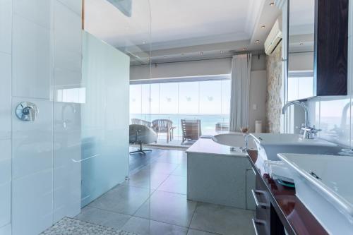 a bathroom with two sinks and a large window at Head over Hills in Knysna