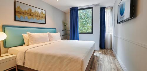 a bedroom with a large bed and a window at J-Hotel by Dorsett in Kuala Lumpur