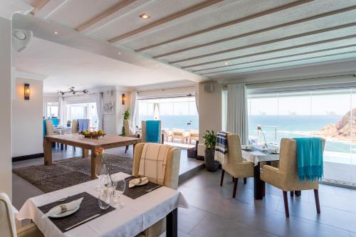 a dining room with a view of the ocean at Head over Hills in Knysna