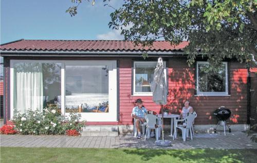 two people sitting at a table outside of a house at Mindegården in Hejls