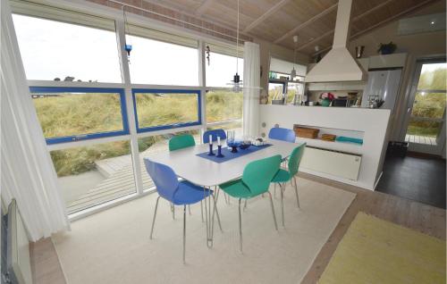a dining room with a table and chairs and large windows at Holiday Home Harrietsvej in Grønhøj