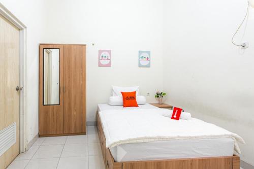 1 dormitorio con 2 camas y espejo en RedDoorz Syariah near Assalaam - UMS, en Solo