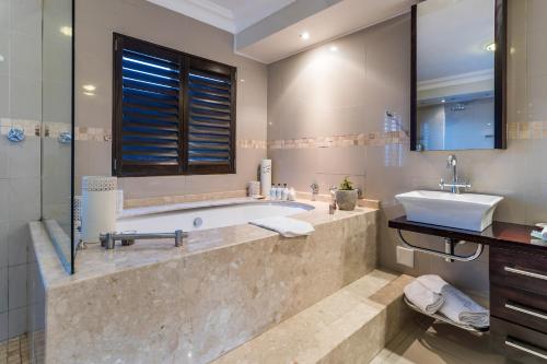 a bathroom with a tub and a sink at Head over Hills in Knysna