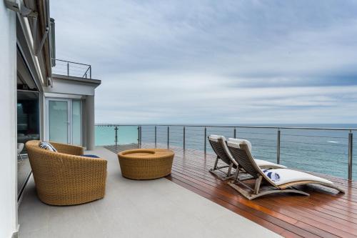 a balcony with chairs and a view of the ocean at Head over Hills in Knysna